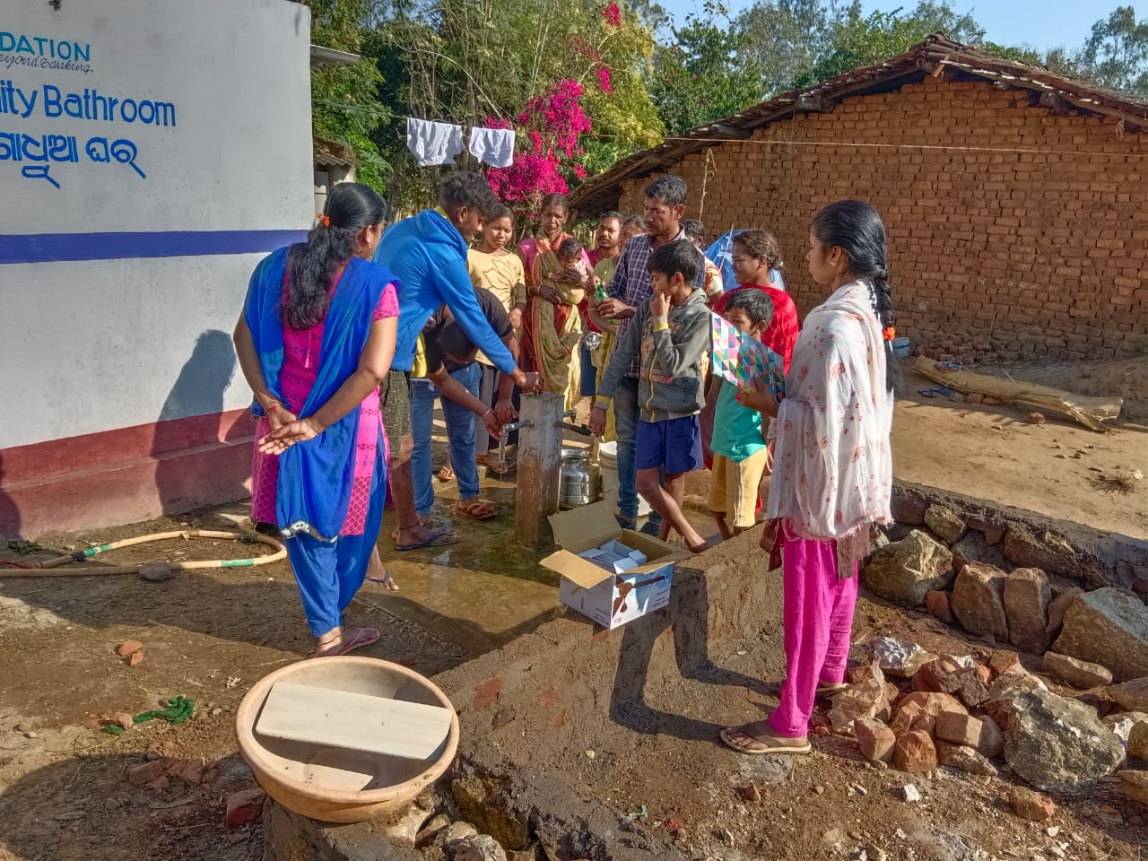 A community gathered around a local water point during a field programme.